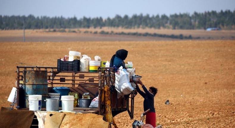 Displaced Syrians, who fled their hometowns due to clashes between regime forces and the Islamic State (IS) group, prepare food in Kharufiyah, 18 kilometres south of Manbij, on March 4, 2017