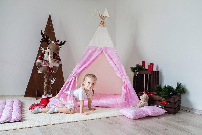 Little girl playing in a tent.