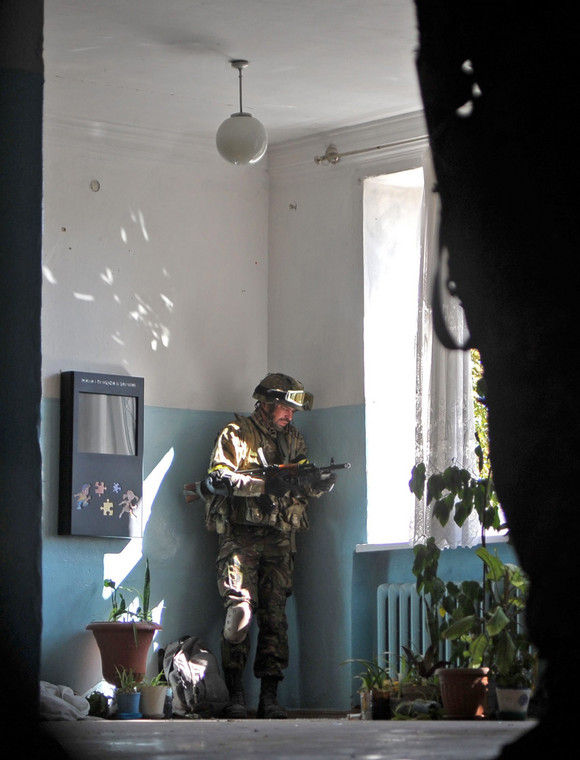 Ukraiński żołnierz z batalionu Donbas chroni się w mieszkaniu w Iłowajsku po starciu z rebeliantami