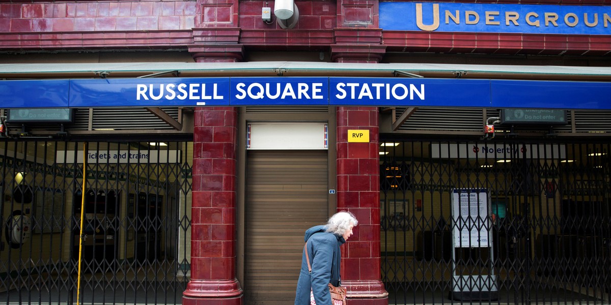 FILE PHOTO - A woman walks past a closed entrance of Russell Square underground station in London April 29, 2014.