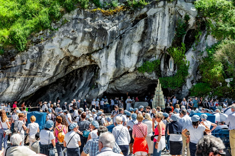 Pielgrzymi u wejściu do groty w Lourdes