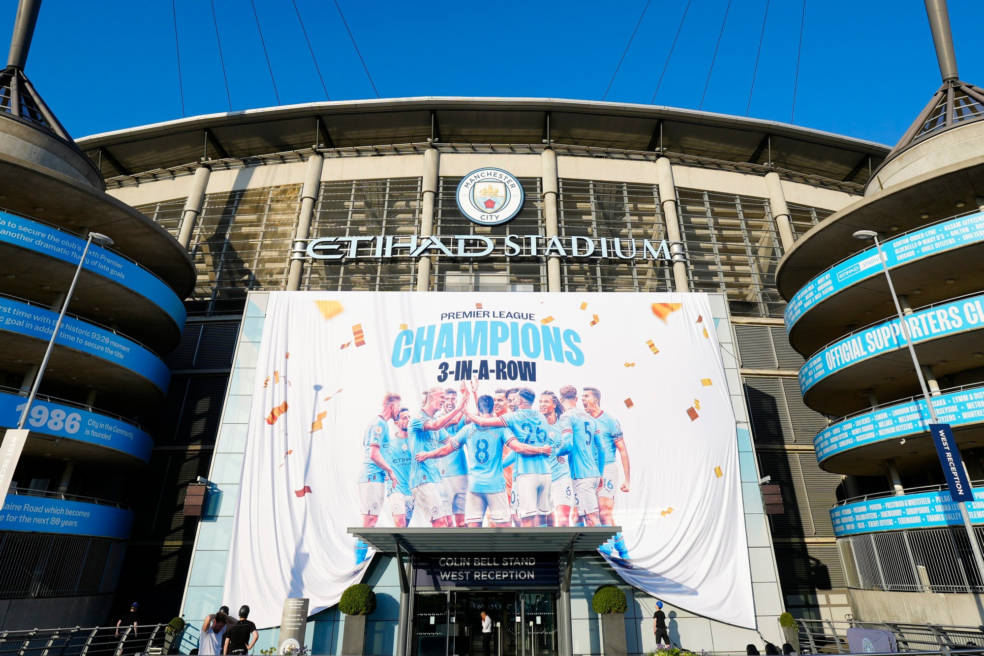 Fanúšikovia Manchestru City oslavujú obhajovu titulu pred Etihad Stadium.