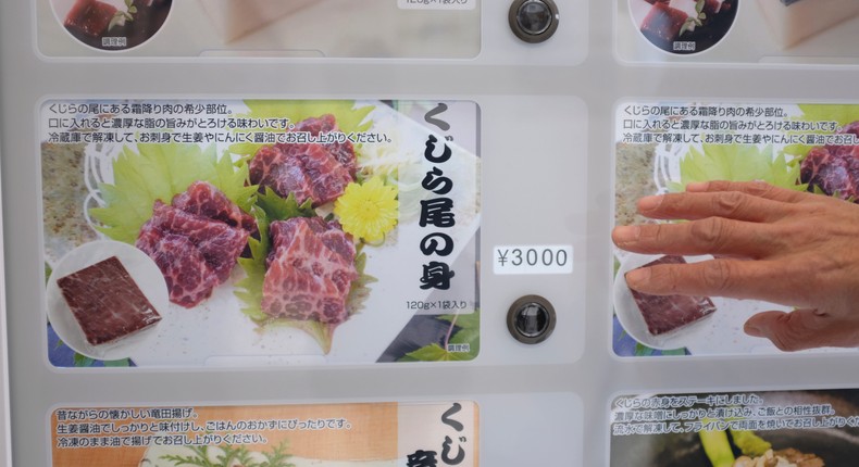 Konomu Kubo, a spokesperson for Kyodo Senpaku Co. points as he explains how whale meat is being sold from a vending machine at the firm's store on January 26 in Yokohama, Japan.Kwiyeon Ha/AP