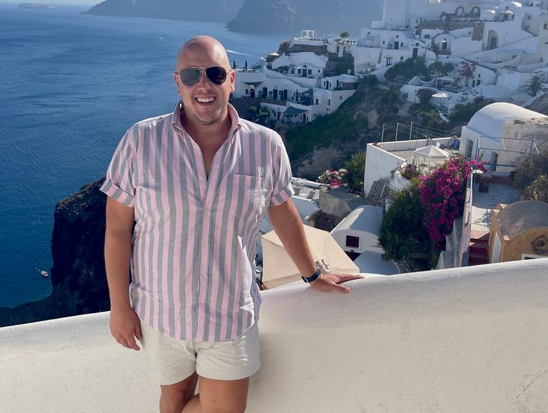 Seen here traveling to Santorini, Greece, Jason Poole travels as a travel agent to experience cities and cruise ships for the first time.