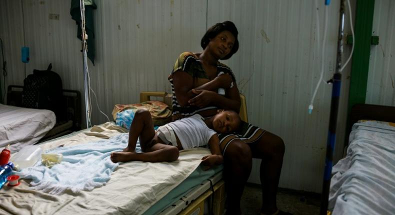 A young patient lies on his mother's lap at the postoperative ward during a doctors' strike at the public hospital in Port-au-Prince