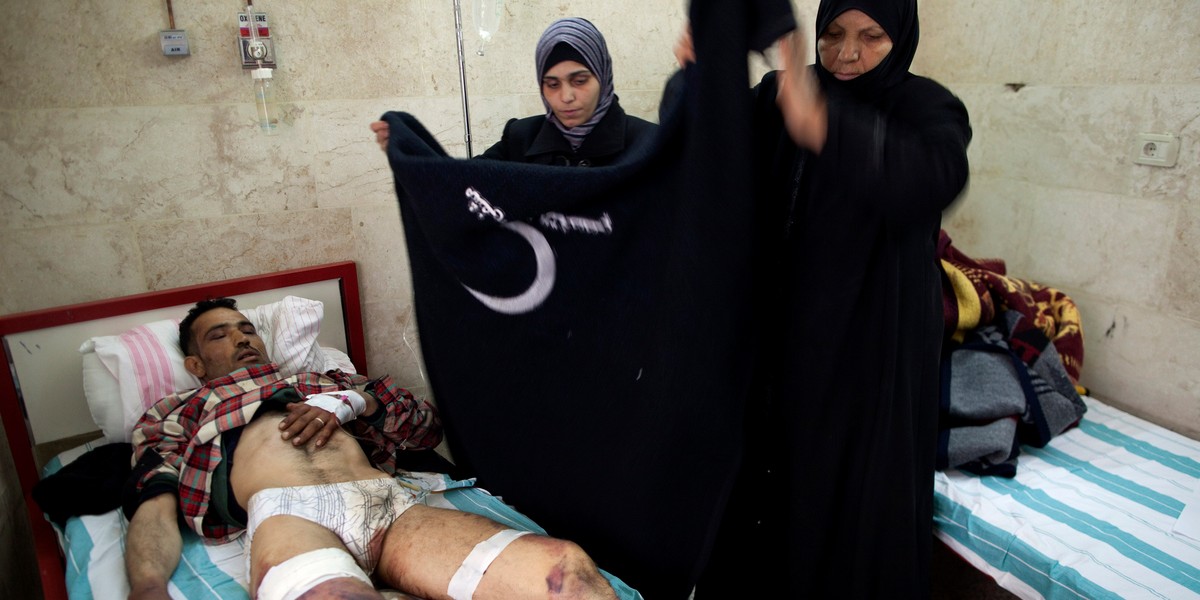 Relatives care for Mohammed Obed, who is recovering in a hospital after being captured and allegedly tortured by Syrian army soldiers, in Idlib, Syria, on March 7, 2012.