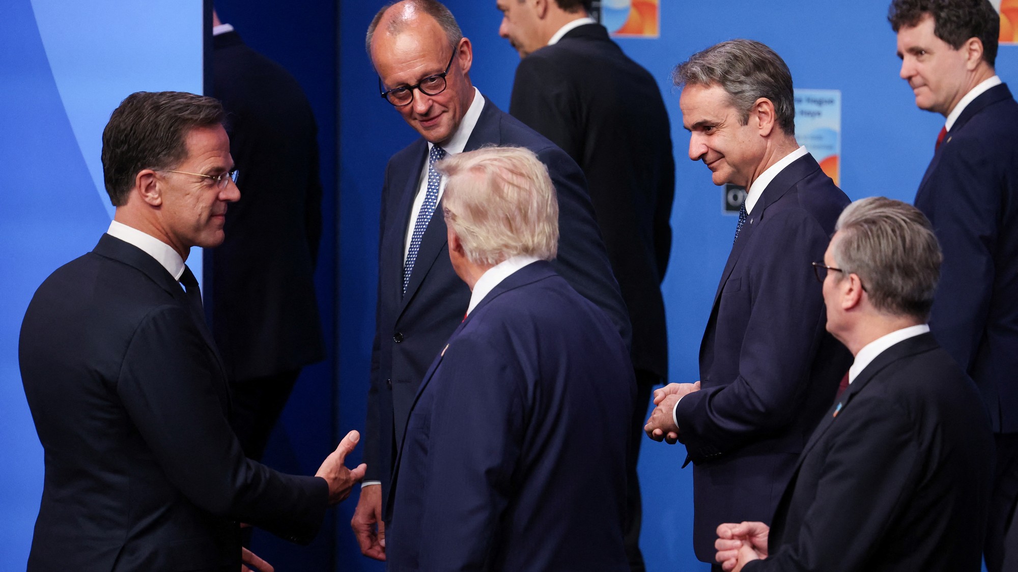 Nemecký kancelár Friedrich Merz sa pozerá na amerického prezidenta Donalda Trumpa vedľa generálneho tajomníka NATO Marka Rutteho, gréckeho premiéra Kyriakosa Mitsotakisa a britského premiéra Keira Starmera počas rodinnej fotografie lídrov NATO na samite NATO v Haagu.