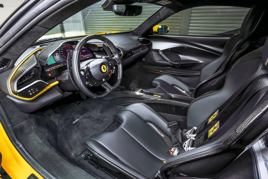 Kokpit Ferrari 296 GTB jest zorientowany na kierowcę, a obsługa – nieskomplikowana. Słabe podparcie boczne opcjonalnych foteli karbonowych