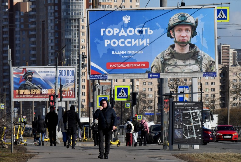 Ludzie przechodzą obok billboardów promujących służbę w armii kontraktowej, Sankt Petersburg, Rosja, 19 marca 2025 r.