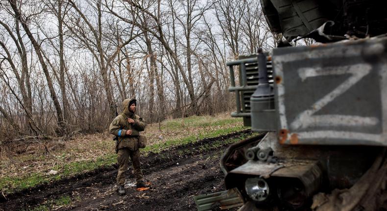 A Ukrainian soldier stands next to a destroyed Russian anti-aircraft missile system, marked with the Z symbol, in the village of Husarivka in Kharkiv region, Ukraine, on April 14, 2022.