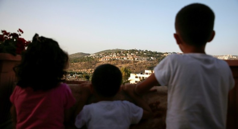 Children from the Palestinian village of Deir Ibzi in the Israeli-occupied West Bank look at the Jewish settlement of Dolev on May 10, 2017