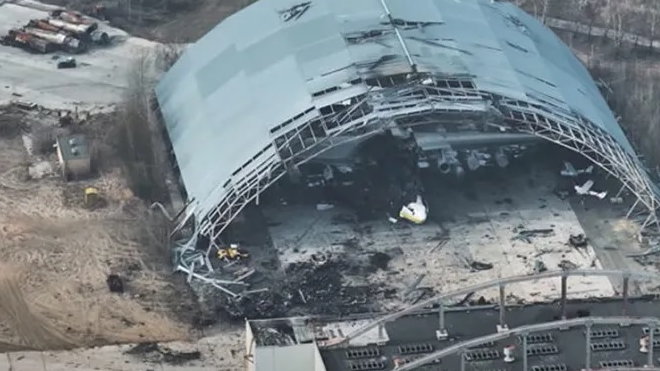 Hangar ze zniszczonym samolotem transportowym An-225 Mrija. Został  on ostrzelany przez ukraińską artylerię, która zniszczyła ustawione w jego pobliżu rosyjskie wozy bojowe. Wycofując się z lotniska, rosyjscy żołnierze ostrzelali z broni maszynowej inne zaparkowane na lotnisku ukraińskie cywilne samoloty transportowe, więc zapewne zniszczona zostałaby w ten sposób także Mrija