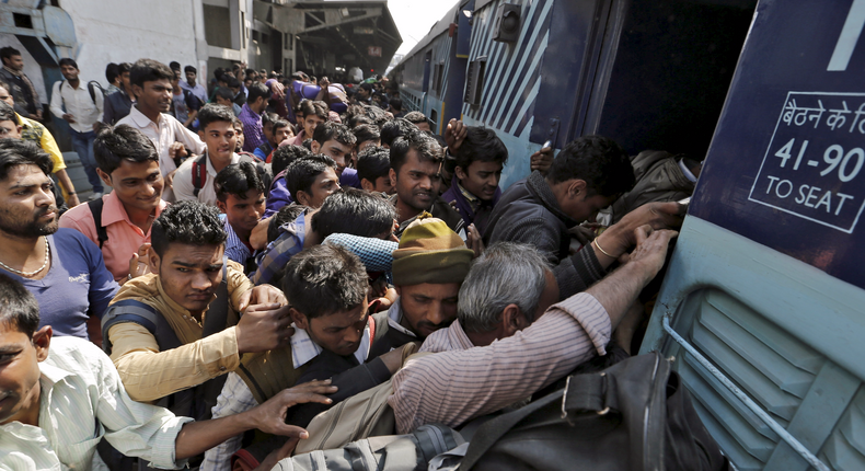 People board a passenger train at a railway station in New Delhi, India, February 25, 2016.