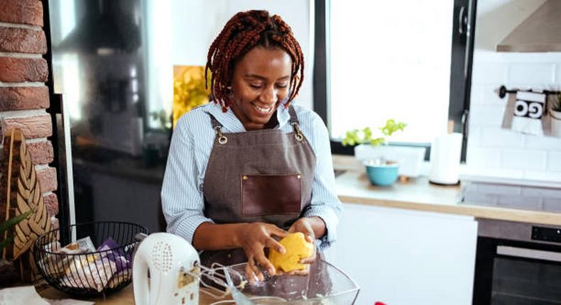 A photo of a woman using a stand mixer in the kitchen