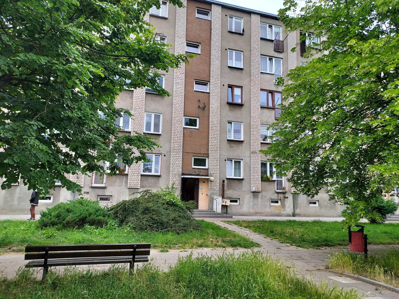 Pięciokondygnacyjny blok na osiedlu Wyzwolenia – drzwi do środkowej klatki prowadzą do "mieszkania Trynkiewicza" na pierwszym piętrze