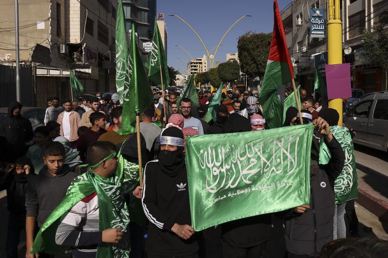 Palestyńczycy ze swoimi flagami narodowymi oraz flagami ruchu Hamas podczas wiecu w mieście Hebron na Zachodnim Brzegu, grudzień 2023 r.