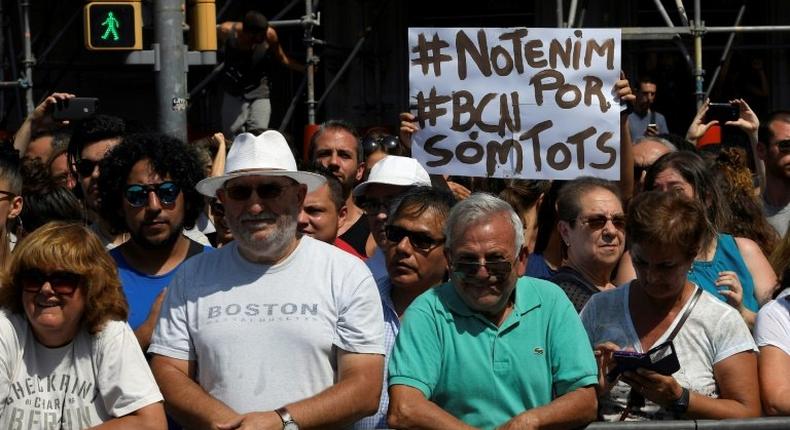 Somebody holds up a sign reading We are not afraid. Barcelona, we are all before a crowd observes a minute of silence for the victims of the Barcelona attack at Plaza de Catalunya on August 18, 2017