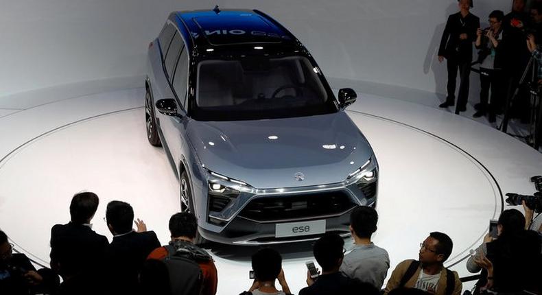 People gather at the booth of Chinese electric vehicle start-up Nio as it unveils its ES8 SUV at the Shanghai auto show, in Shanghai