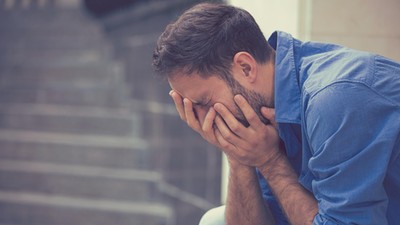 stressed sad crying man sitting outside