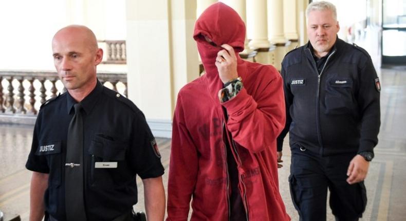 A 21-year-old Dutchman is escorted into court by officers for the first trial over violent riots against the G20 summit in Hamburg, northern Germany on August 28, 2017