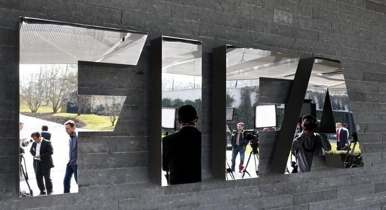 Journalists are reflected in the FIFA logo as they wait for a news conference after a meeting of the FIFA executive committee in Zurich March 20, 2015. REUTERS/Arnd Wiegmann