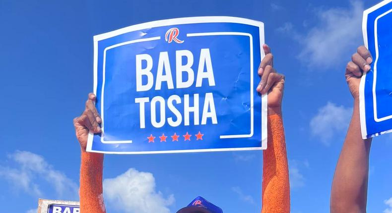 A fan holds up a sign reading Baba Tosha during Raila Odinga's Coastal tour with the Azimio La Umoja campaign on May 14, 2022