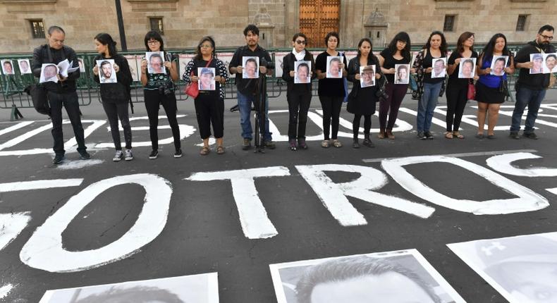 Members of the press hold images of colleagues during a protest against the murder or disappearance of journalists and photojournalists in Mexico, in front of the National Palace in Mexico City on June 1, 2018