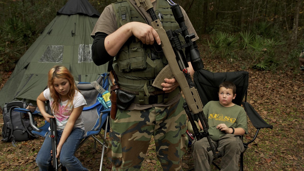 Member of the North Florida Survival Group wait with their rifles before heading out to perform enem