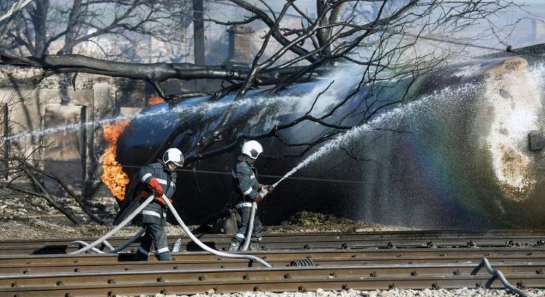 Firefighters spray water on a train that derailed in the northeastern Bulgarian village of Hitrino on December 10, 2016