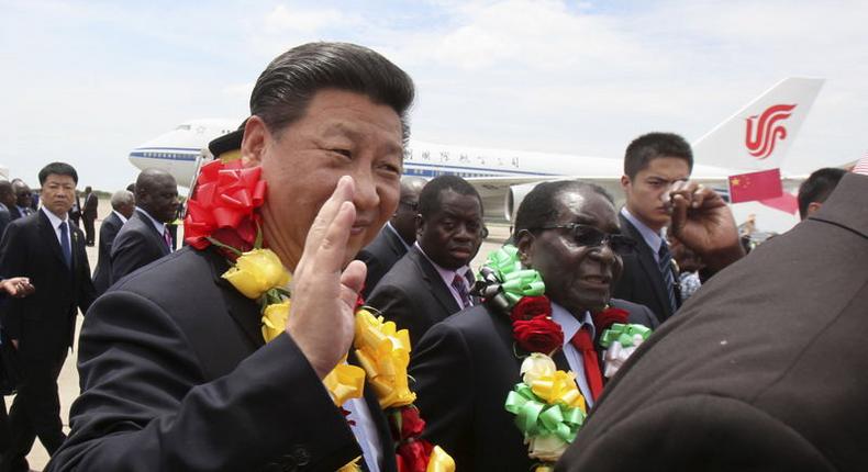 Chinese President Xi Jinping waves as he walks with Zimbabwean President Robert Mugabe (2nd L) upon arrival for a state visit in Harare, Zimbabwe December 1, 2015. REUTERS/Philimon Bulawayo