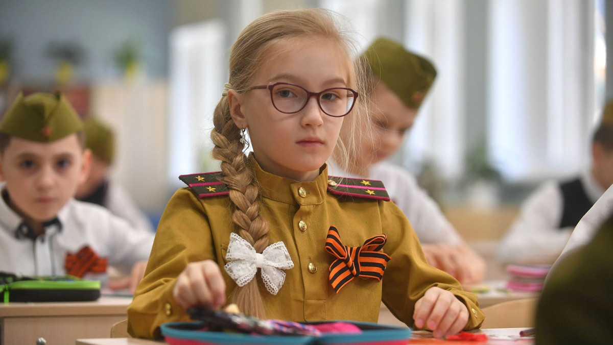 Dziewczynka z jednej z moskiewskich szkół podstawowych ma na sobie replikę munduru żołnierza Armii Czerwonej, a w klapie wstążkę św. Jerzego oznaczającą poparcie dla wojsk rosyjskich w Ukrainie