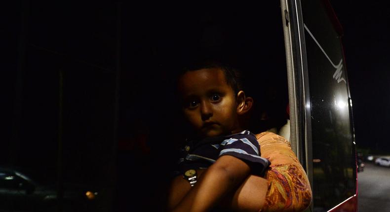 A Honduran child sits on his mother's lap aboard a bus leaving the Metropolitan Center of San Pedro Sula, 300 kms north of Tegucigalpa, travelling towards the Guatemala border on April 9, 2019.AFP/Orlando Sierra via Getty Images