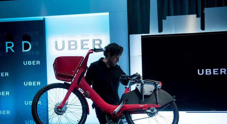 uber jump bike carry A man removes a JUMP bike during an event at the Uber DC Green-light Hub April 11, 2018 in Washington, DC. / AFP PHOTO / Brendan Smialowski (Photo credit should read BRENDAN SMIALOWSKI/AFP via Getty Images)