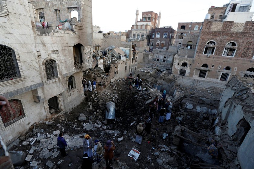 People gather at the site of an air strike in Sanaa, Yemen