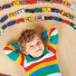 Cute little blond kid boy playing with lots toy cars