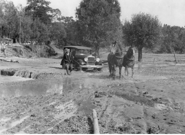 Zaprzęg konny wyciągający samochód osobowy z błota, 1934 r.