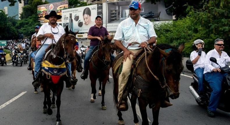 In the Venezuelan capital Caracas protesters on motorcycles, bikes and even horseback tried to clog a key highway clashing with riot police firing tear gas