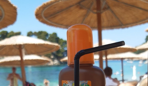 Piće, ležaljka, suncobran na plaži, još i krofna
