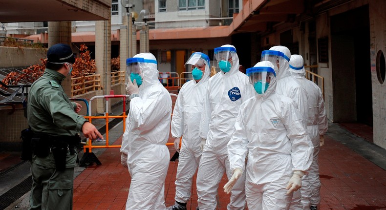 Police in protective gear wait to evacuate residents from a public housing building, following the outbreak of the novel coronavirus, in Hong Kong, China February 11, 2020. REUTERS/Tyrone Siu