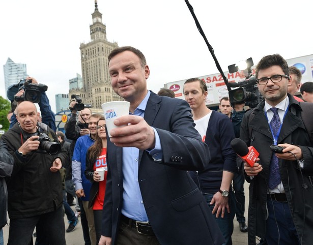 Kandydat na prezydenta Andrzej Duda (C) rozdaje kawę przed wejściem na stację metra Centrum w Warszawie, 11 bm. Duda, który wg sondaży wygrał I turę wyborów, w drugiej turze 24 bm. zmierzy się z Bronisławem Komorowskim. (zuz) PAP/Marcin Obara