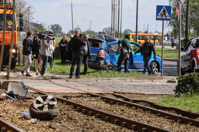 Samochód zaklinowany pomiędzy tramwajem a słupem. W środku ciężarna kobieta i dziecko