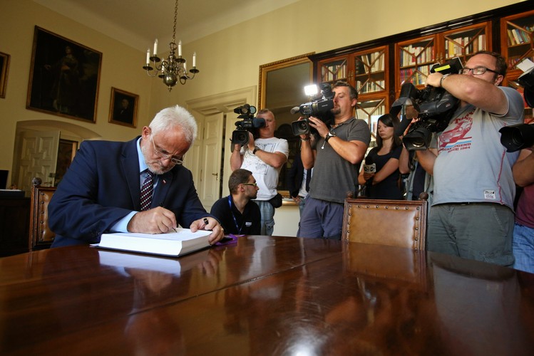 Wojewoda małopolski Józef Pilch wpisuje się do księgi kondolencyjnej wyłożonej w Pałacu Arcybiskupów Krakowskich