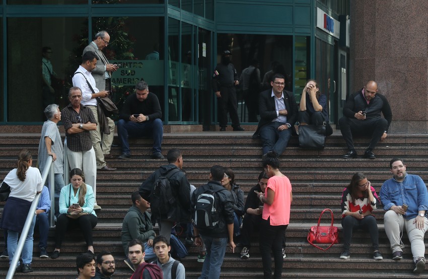 Ljudi čekaju ispred zgrade dok traje akcija policije