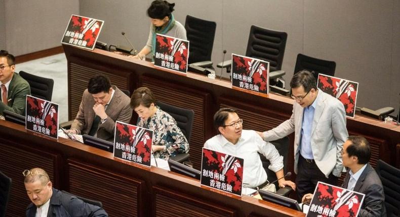 Pro-democracy lawmakers display signs reading ceding land with co-location puts Hong Kong in danger during a meeting to discuss the high-speed rail link
