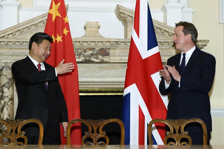 UK Prime Minister David Cameron applauds alongside Chinese President Xi Jinping at the trade deal exchange at the UK-China business summit at Mansion House in central London on October 21, 2015.