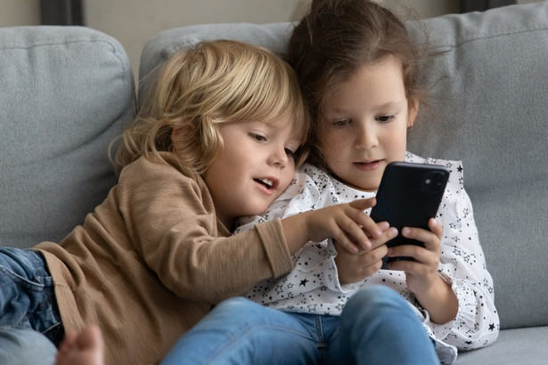 Dzieci oglądają smartfon.