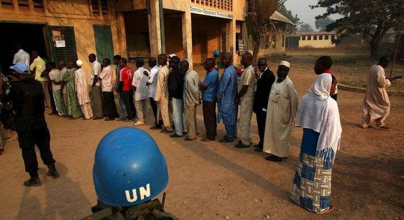 A United Nations security officer keeps guard as people wait in line to cast their votes during the second round of presidential and legislative elections in the mostly Muslim PK5 neighbourhood of Bangui, Central African Republic, February 14, 2016. REUTERS/Siegfried Modola