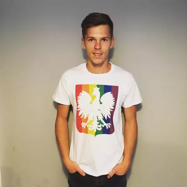 Arek Kluk w koszulce Out and Proud z orłem wpisanym we flagę LGBT