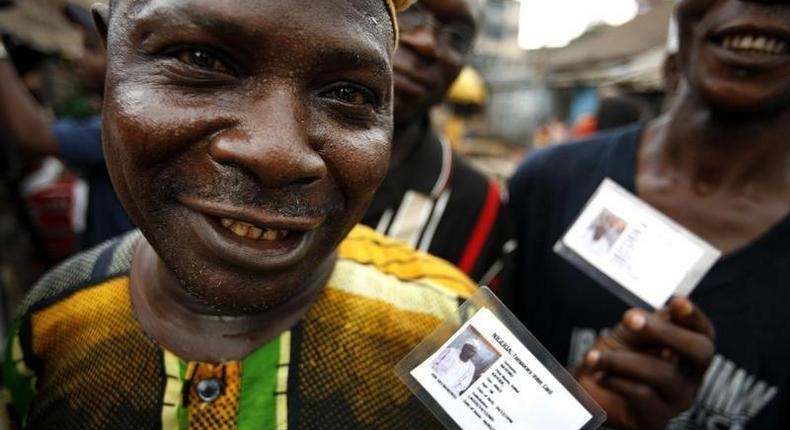 Nigerian voters show off their identity cards while lining up to vote in the neighbourhood of Isale-Eko in in a file photo. REUTERS/Finbarr O'Reilly