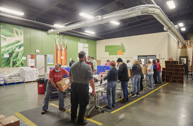 Wolontariusze w centrum dystrybucyjnym Banku Żywności (Food Bank) pakują paczki z artykułami spożywczymi. Omaha, Nebraska, USA. 8.12.2021